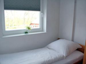 a small bedroom with a bed and a window at Luna-Wohnung-12 in Sankt Peter-Ording