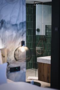 a bathroom with a shower with a sink and a mirror at Berghotel Hochfügen in Hochfugen