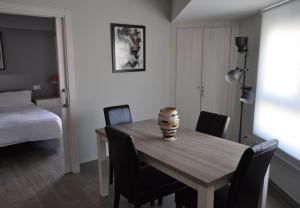 een kamer met een houten tafel met stoelen en een bed bij III Apartamento junto a PLAZA MAYOR in Salamanca