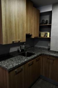 een keuken met een wastafel en houten kasten bij III Apartamento junto a PLAZA MAYOR in Salamanca