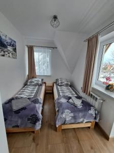 two beds in a room with a window at Willa Ciupaga in Kościelisko