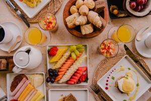 a table topped with plates of food and glasses of orange juice at Ponta de Inhambupe Hotel Boutique & Spa by Slaviero Hoteis in Baixio