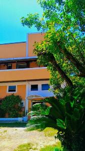 un edificio con un árbol delante de él en Hotel Sol do Pernambuco en Guarujá