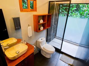 a bathroom with a sink and a toilet and a window at Jardines Secretos in Rivas +75 photos