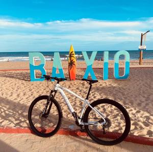 a bike parked on the beach next to a sign at Ponta de Inhambupe Hotel Boutique & Spa by Slaviero Hoteis in Baixio