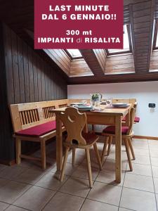 comedor con mesa de madera y sillas en MANSARDA MARMOLADA sui campi da sci, en Alba di Canazei