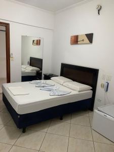a bedroom with a large bed with a mirror at Hotel Sol do Pernambuco in Guarujá