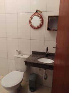 een badkamer met een toilet, een wastafel en een spiegel bij Casa na praia - Balneário Gaivotas in Itanhaém