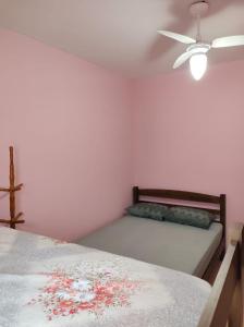 een slaapkamer met 2 bedden en een plafondventilator bij Casa na praia - Balneário Gaivotas in Itanhaém