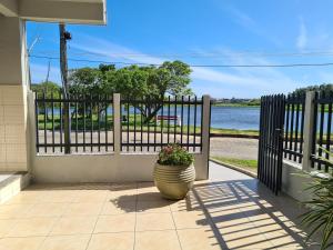 a porch with a flower pot in front of a fence at Sobrado perto da Praia de Frente para Lagoa - Garopaba in Garopaba