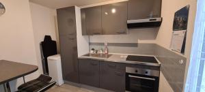 a small kitchen with a sink and a stove at Duplex F3 hypercentre Cherbourg près du port in Cherbourg en Cotentin