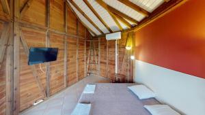 Cette chambre comprend un lit dans une cabane en bois. dans l'établissement Baobab Guadeloupe, à Sainte-Anne