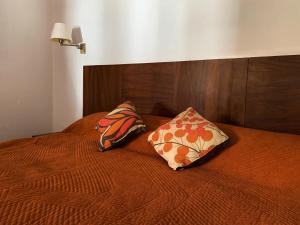 a bed with two pillows on top of it at Hotel Posada Santa Rita in Mascota