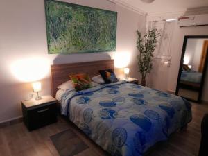 ein Schlafzimmer mit einem Bett, zwei Lampen und einem Gemälde in der Unterkunft APTO 11 CALI - sur in Cali
