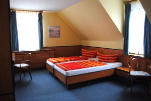 a bedroom with two beds and two chairs in it at Haus Kathrin 