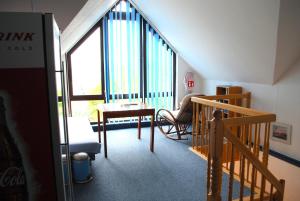 a room with a staircase and a table and a window at Haus Kathrin in Zecherin