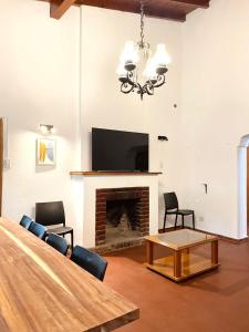 sala de estar con chimenea y TV de pantalla plana en Hermosa y amplia casa en la mejor ubicacion de Chacras, con piscina y jardin en Luján de Cuyo