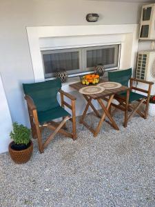 2 sedie e un tavolo con un cesto di frutta su un patio di Holiday Center a Karpathos