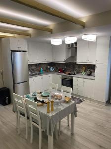 una cucina con tavolo, sedie e frigorifero di Holiday Center a Karpathos