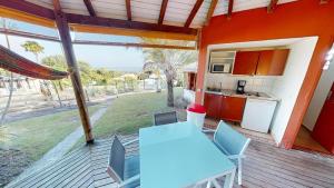 cocina y terraza con mesa y sillas. en Baobab Guadeloupe, en Sainte-Anne