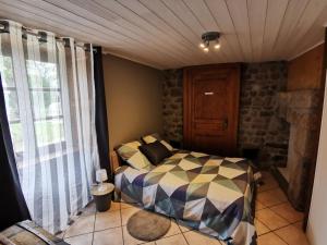 1 dormitorio con 1 cama en una habitación con ventana en Gite du platane, en Grazac