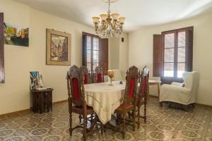 comedor con mesa, sillas y lámpara de araña en Bienvenidos a la Casa del Realejo, en Granada