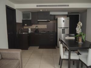 cocina con mesa y nevera en #2 Suite luxury - Puerto Santa Ana, en Guayaquil