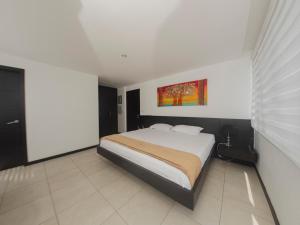 1 dormitorio con 1 cama y una pintura en la pared en #2 Suite luxury - Puerto Santa Ana, en Guayaquil