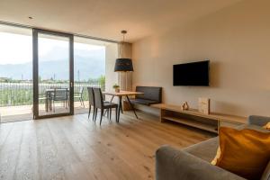 a living room with a television and a table with chairs at Feldhof Vilpian- Urlaub auf dem Bauernhof in Vilpiano