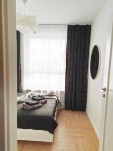 a bedroom with a bed in front of a window at Apartament Kilińskiego in Siedlce