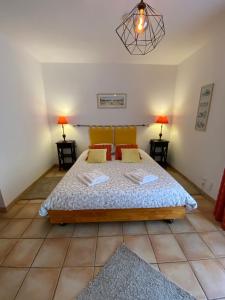 a bedroom with a bed and two lamps on two tables at Gîte Le Sirocco Le Moulin de Prédelles in Reillanne