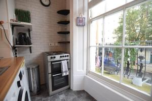 a kitchen with a stove and a window at Fabulous Studio Apartment Camden in London