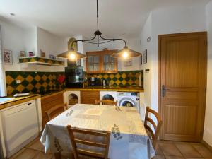 a kitchen with a table and chairs and a kitchen with a stove at Gîte Le Sirocco Le Moulin de Prédelles in Reillanne