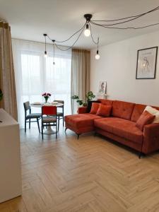 a living room with a red couch and a table at Apartament Kilińskiego in Siedlce