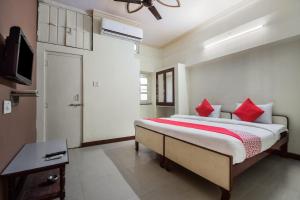a bedroom with a large bed with red pillows at Anand Hotel Jodhpur in Jodhpur