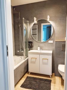 a bathroom with a white sink and a mirror at Apartament Kilińskiego in Siedlce