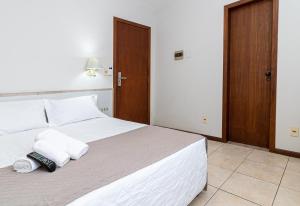 Gaivotas Praia Hotel في فلوريانوبوليس: غرفة نوم بسرير ابيض وعليها وسادتين
