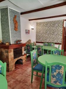 a dining room with a fireplace and green tables and chairs at Villa Sveti Dimitar in Borovets