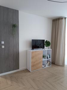 uma sala de estar com televisão num armário branco em Apartament Kilińskiego em Siedlce