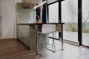 a kitchen with a counter with a chair and a sink at De Veenweide in De Veenhoop