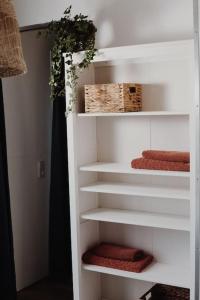 a white book shelf with towels and a basket at De Veenweide in De Veenhoop