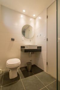 uma casa de banho com um WC, um lavatório e um espelho. em Casa Do Gato Cinzento no Rio de Janeiro