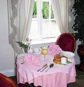 une table avec un tissu de table rose et une assiette de nourriture dans l'établissement Brandon Lodge, à Hereford