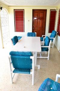 una mesa blanca con sillas azules en una habitación en Castlevue B&B en Montego Bay