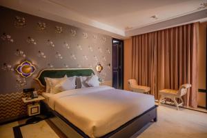 a hotel room with a bed and a window at Bur'Dera - a Boutique Luxury Hotel in Jaipur