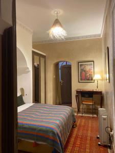 1 dormitorio con cama y escritorio. en Riad au cœur de la médina loué entièrement avec ménage et petit déjeuner compris, en Marrakech