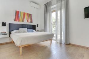 ein Schlafzimmer mit einem großen Bett und einem großen Fenster in der Unterkunft Casa Di Claudia in Rom