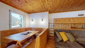 サンモリッツにあるAbitaziun Ruinatsch 22 - St Moritzの木製のテーブルとソファが備わる木造の客室です。