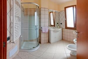 bagno con doccia, lavandino e servizi igienici di Casa Vacanze Porto Corallo a Villaputzu