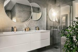 uma casa de banho com um lavatório branco e um espelho. em Villa Bergen. Historic luxury near the city centre em Bergen